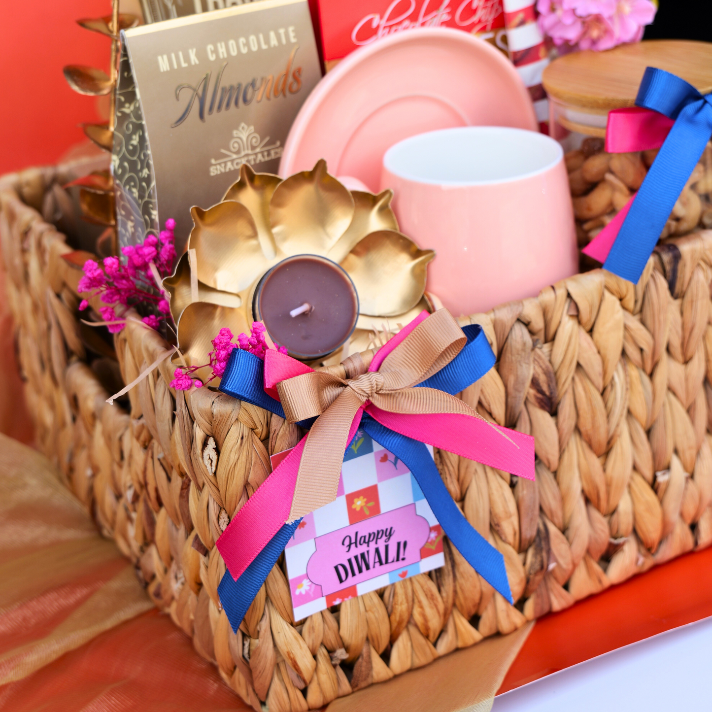 Gift basket with candles, chocolates, and decorative items on a table.