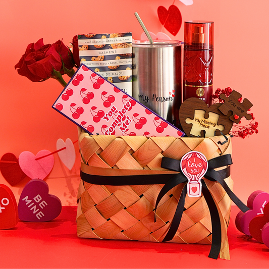 Gift basket with Valentine's Day items including roses, books, a tumbler, and a bottle on a red background.