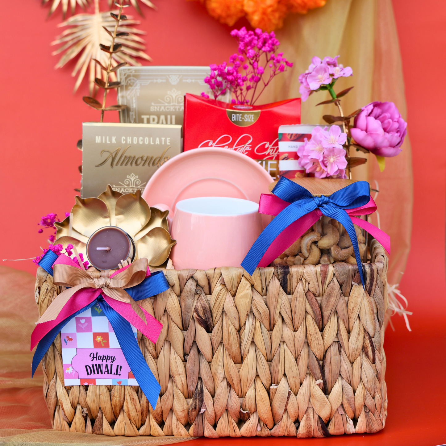 Gift basket with candles, flowers, and chocolate on a red background