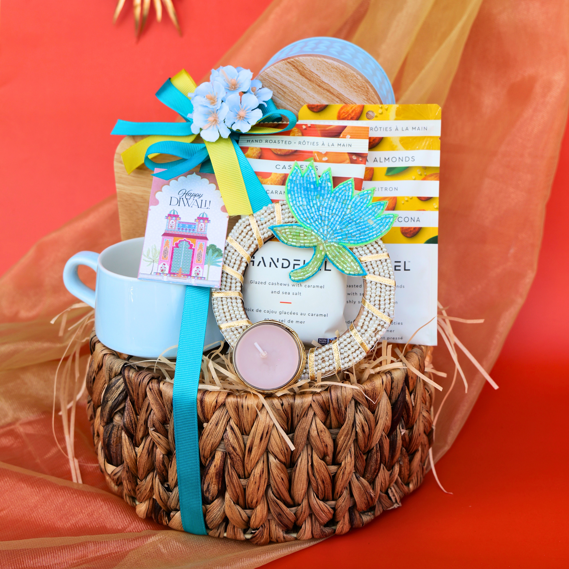 Gift basket with a mug, candle, and decorative items on an orange background