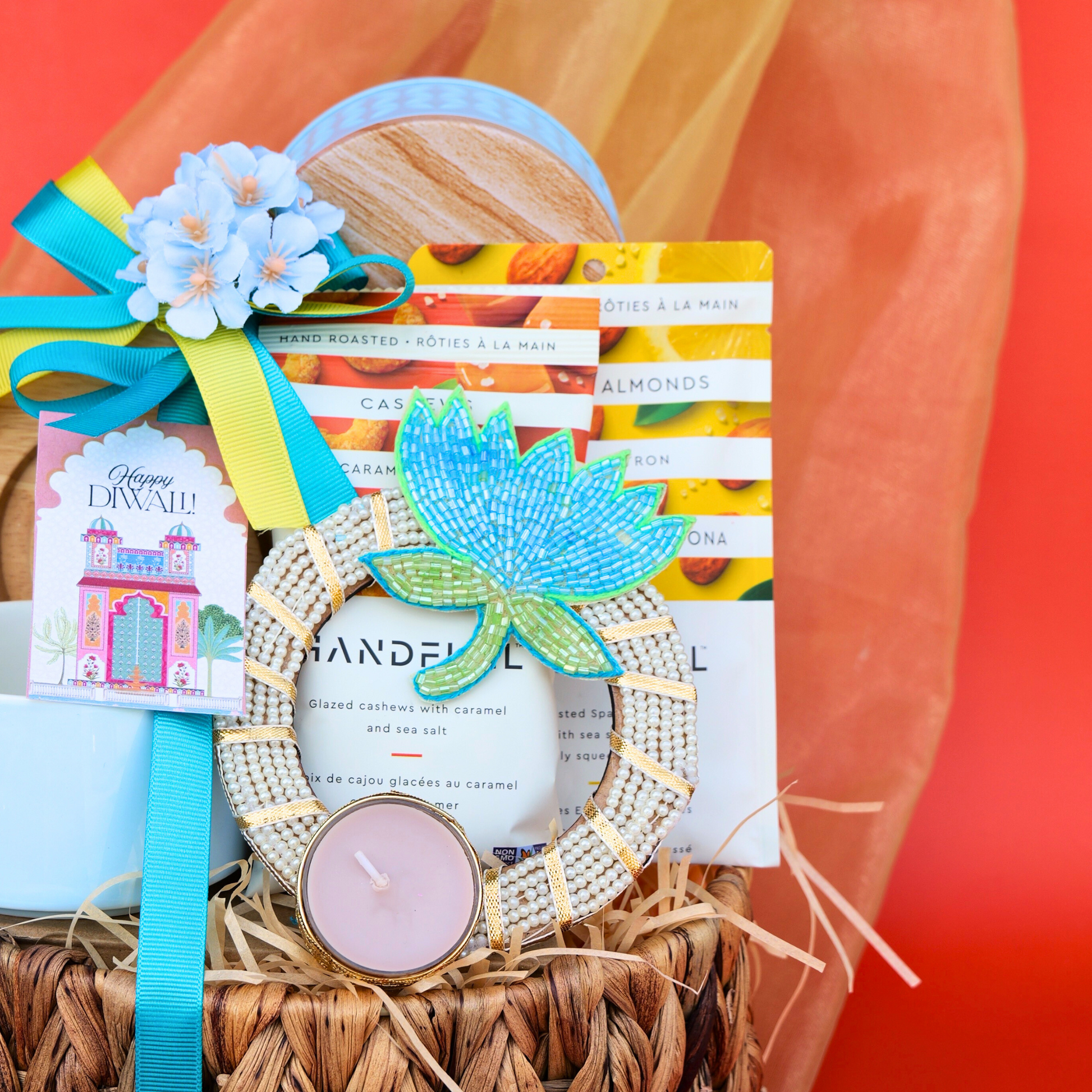 Decorative gift basket with candle, card, and decorative item on a red background