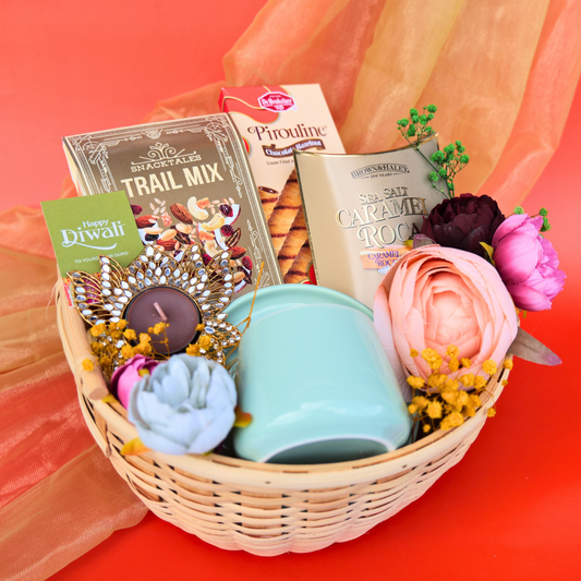 Gift basket with snacks, flowers, and a mug on a red background