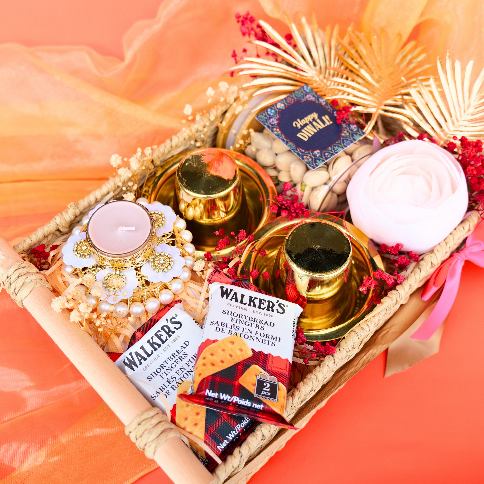 Decorative gift tray with candles, Walker's shortbread, and decorative elements on a bright background