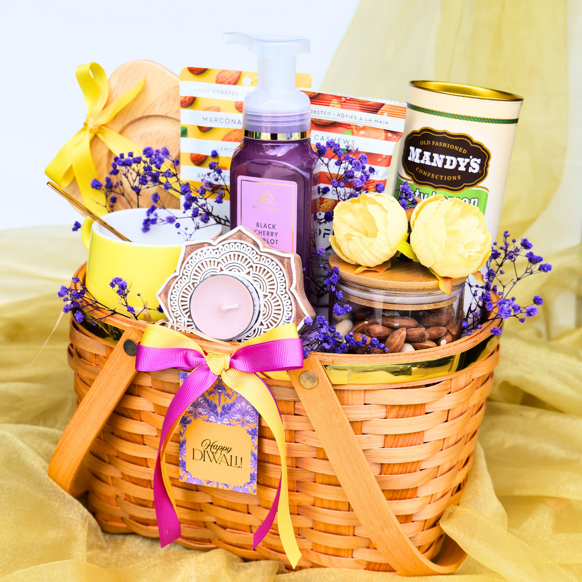Gift basket with candles, soap, and other items on a yellow fabric background