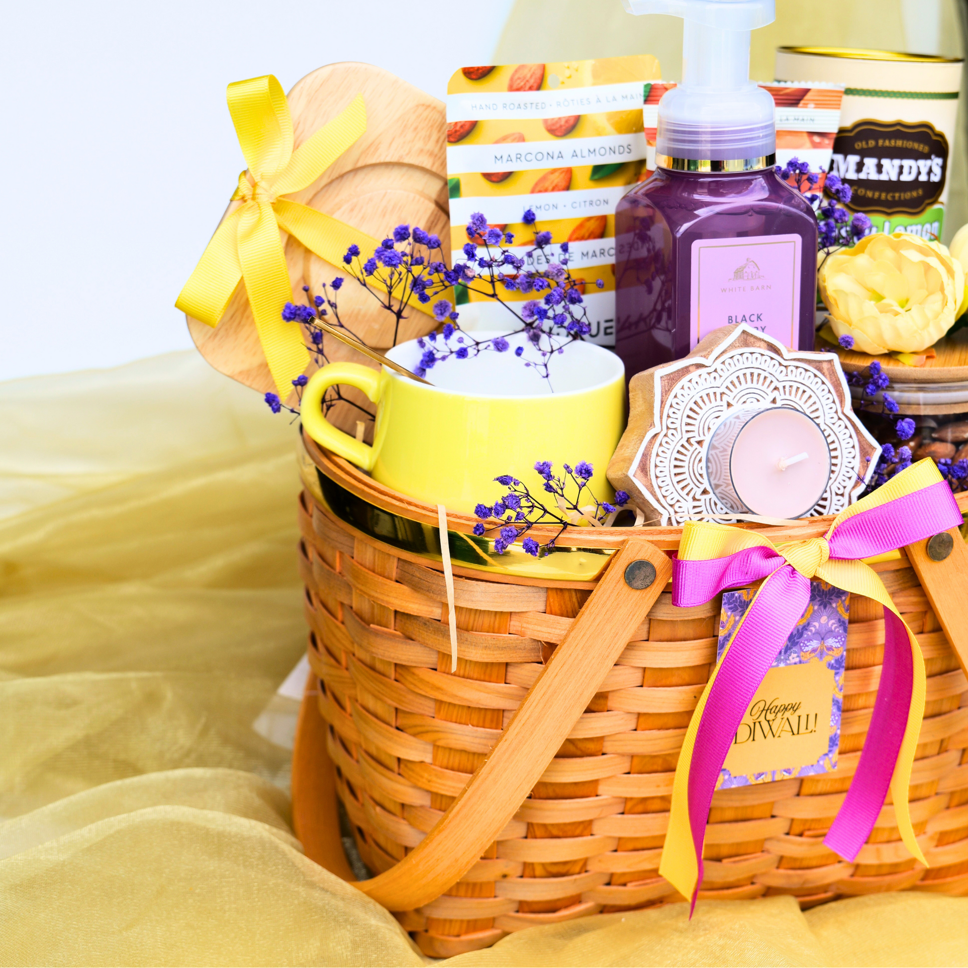 Gift basket with a yellow mug, soap, and other items on a light yellow fabric background