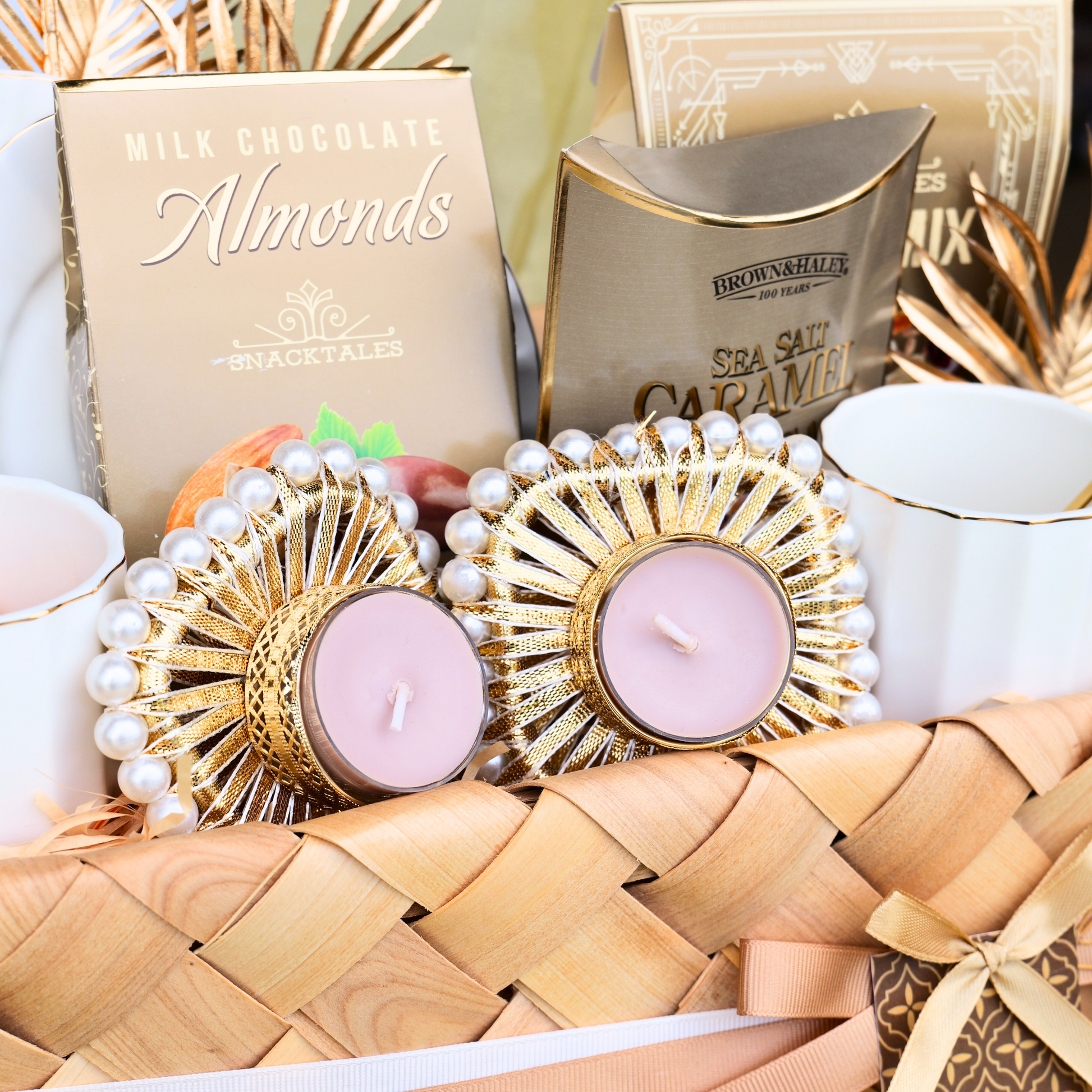 Gift basket with candles, chocolate, and tea on a wooden surface