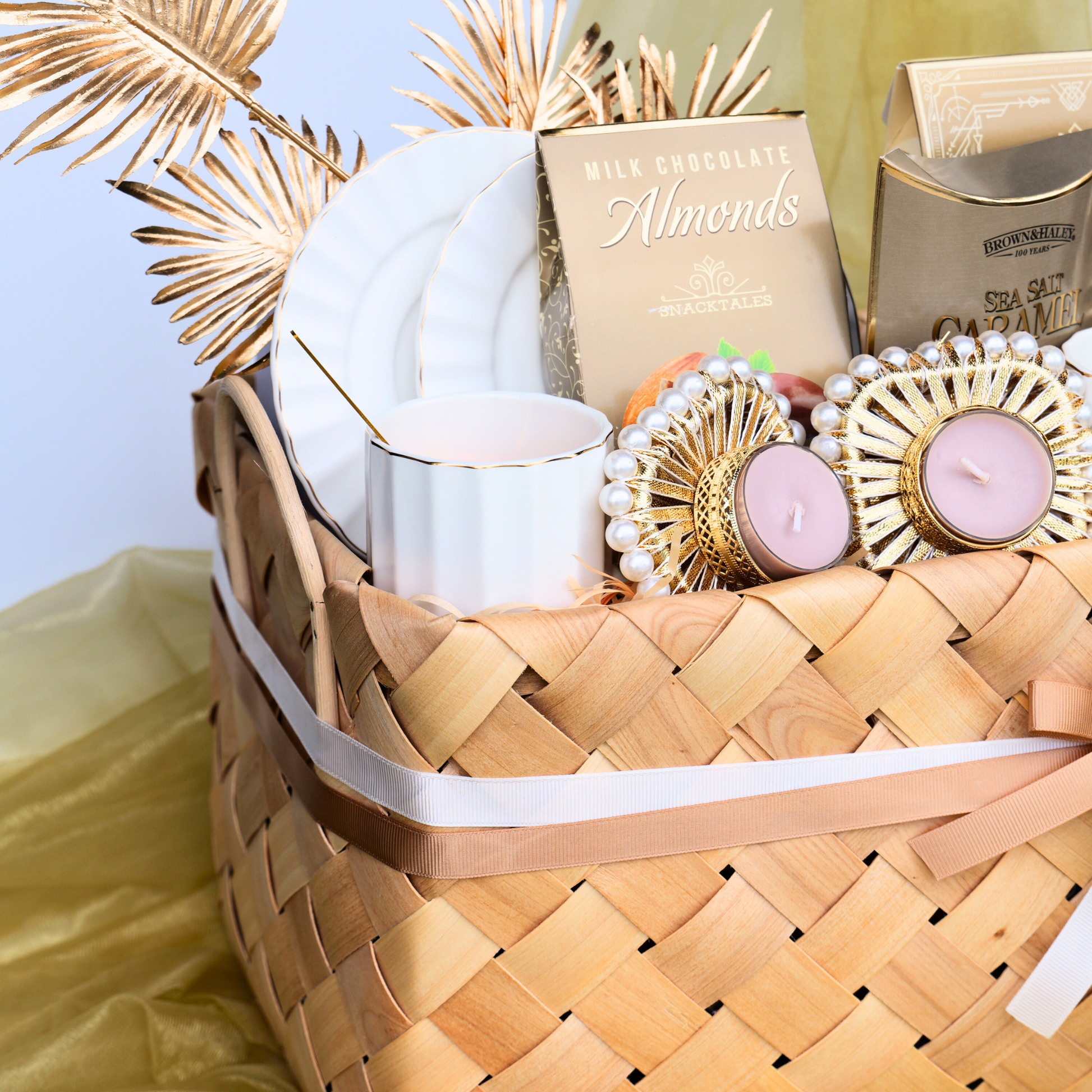 Woven basket with candles, chocolate, and decorative items on a light background