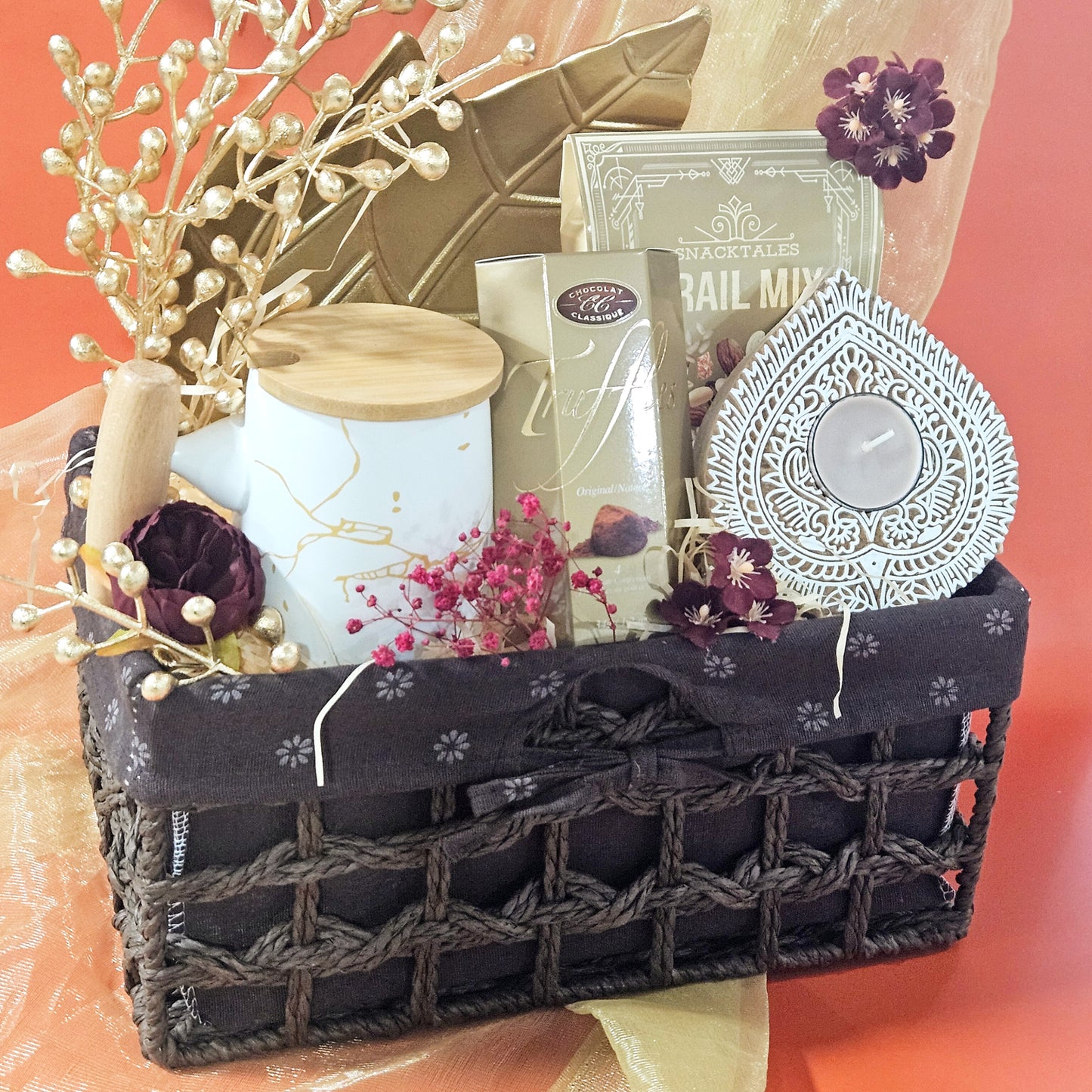 Gift basket with candles, flowers, and decorative items on a peach background
