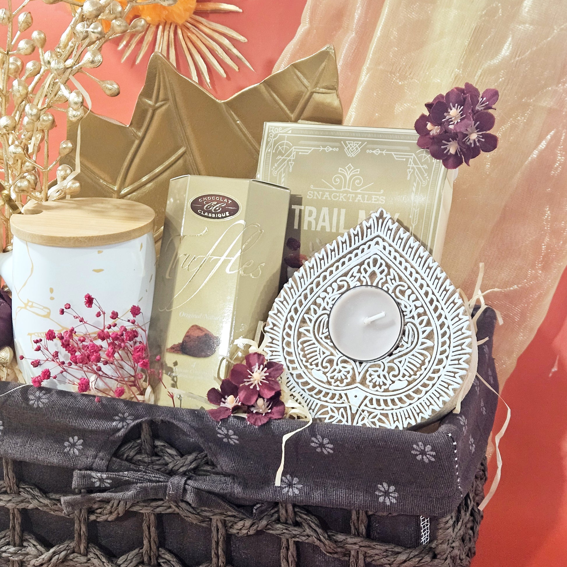Decorative basket with candles, flowers, and decorative items on a red background